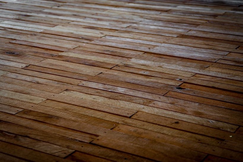 Worn 1970s oak strip flooring in an Edmonton home before it is sanded back to bare wood.